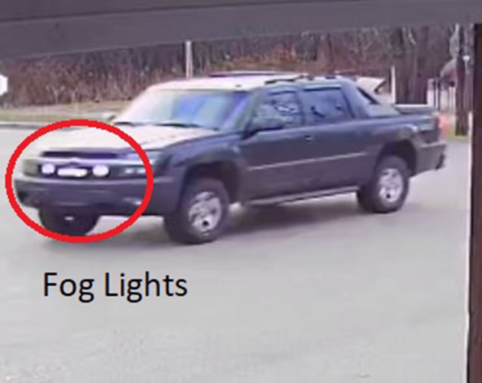 A black Chevrolet Avalanche pickup with a red circle drawn around the lights on its front bumper and the words Fog Lights
